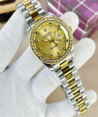 Luxury watch with gold face and silver and gold band on a white glove