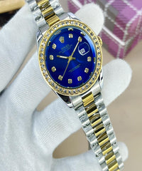 Watch with blue face and gold accents on a white glove