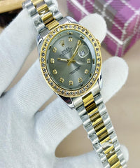 Two-tone watch with silver and gold band on a white glove against a blurred background