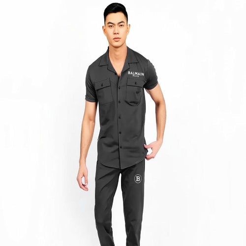 Man wearing a black outfit with Balmain logo on a white background