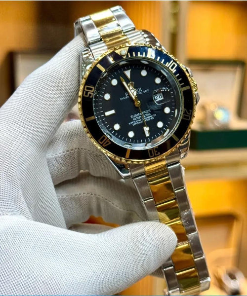 Gold and silver watch with black face held by a gloved hand against a blurred background