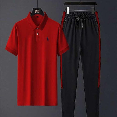 Red polo shirt and black pants with red trim on hangers against a gray background
