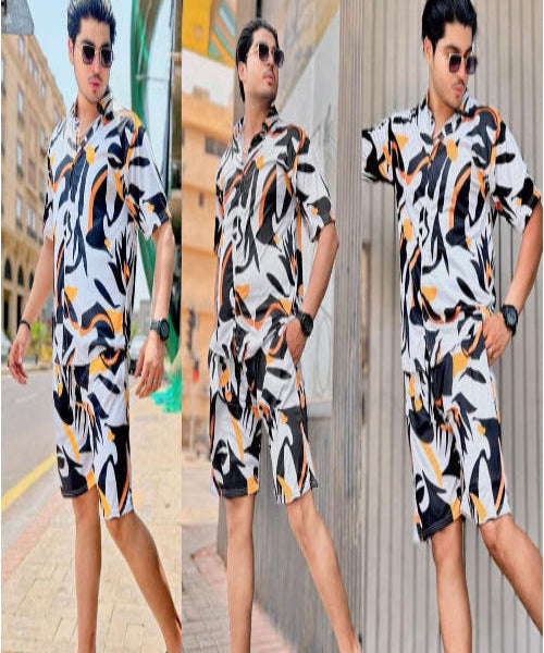 Man wearing a patterned outfit standing on a street with buildings in the background