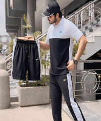Man holding a black and white outfit in an urban setting