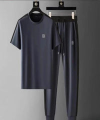 Navy blue t-shirt and pants set on hangers against a gray background