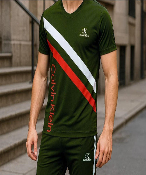 Person wearing a green Calvin Klein outfit with red and white accents on a city street.