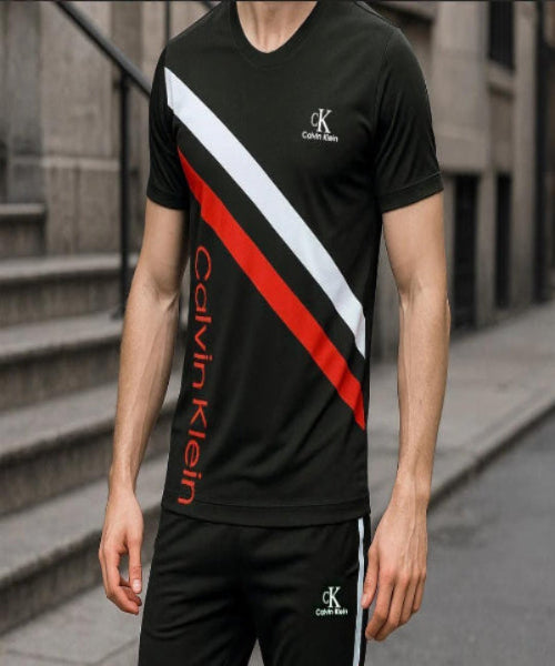 Person wearing a Calvin Klein black and red sports outfit on a city street.